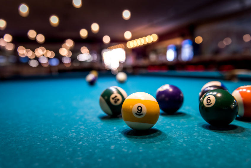 Colorful billiard balls on playing table, dispersed